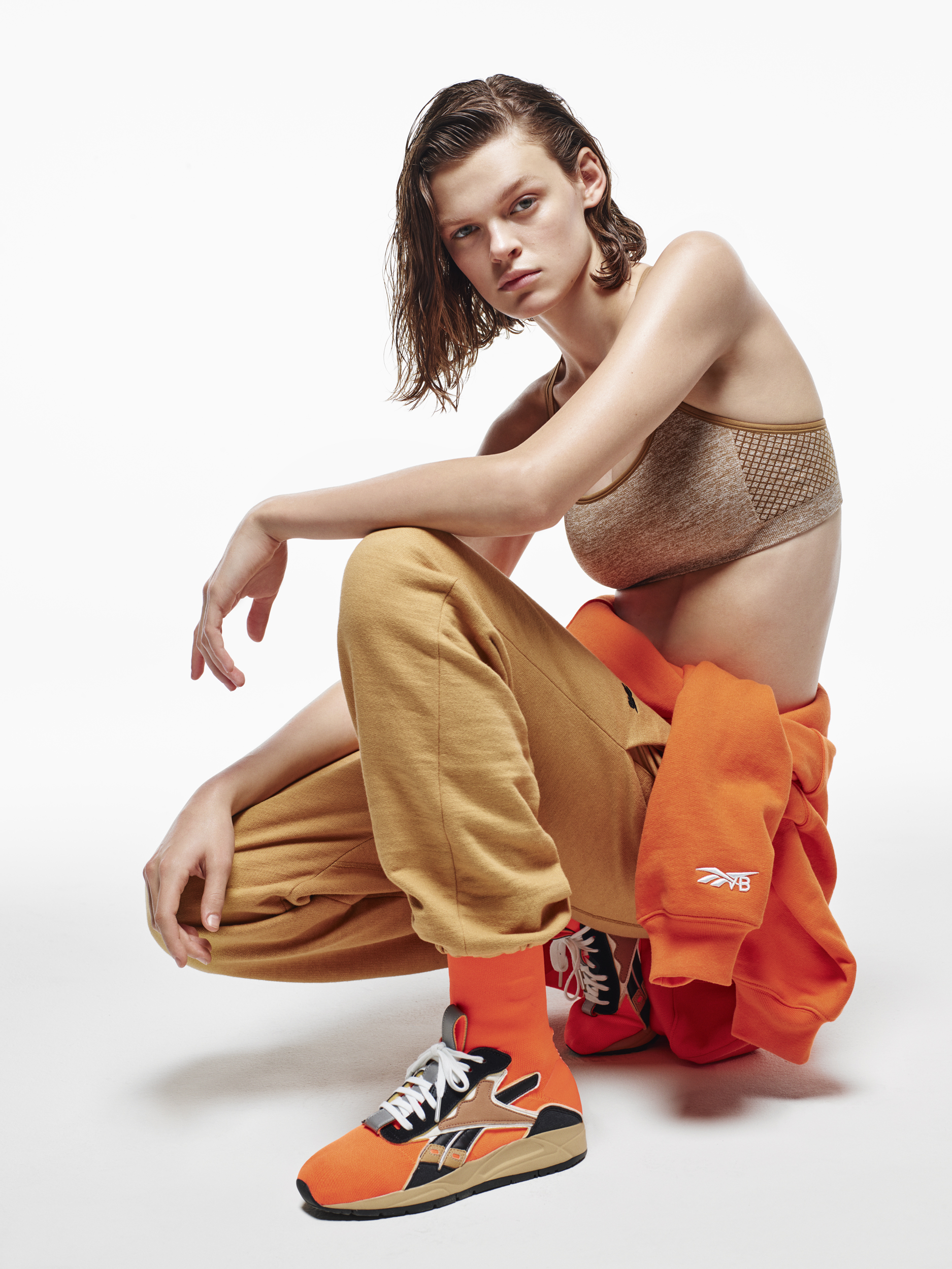 Victoria Beckham-Reebok Model wearing jog bra, orange sweats and sneakers